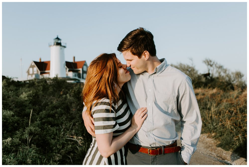 couple kisses in front of lighthouse